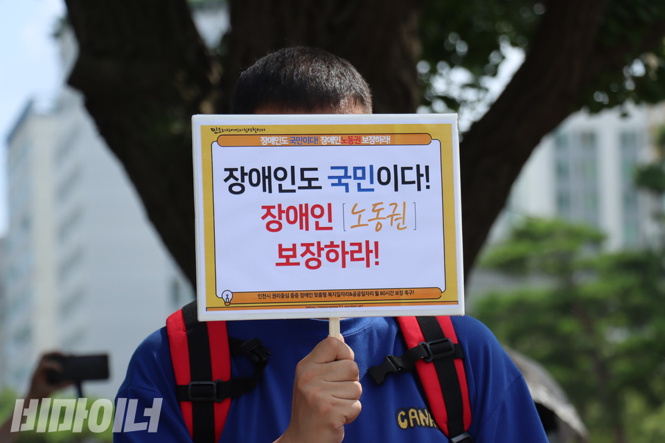 인천장애인차별철폐연대는 지난 7월 30일 인천시청 앞에서 장애인의 노동권을 보장하지 않은 채 권리중심공공일자리를 시행하는 인천시청을 규탄하는 기자회견을 열었다. 기자회견 참석자가 “장애인도 국민이다! 장애인 노동권 보장하라!”라고 적힌 팻말을 들고 있다. 사진 김소영