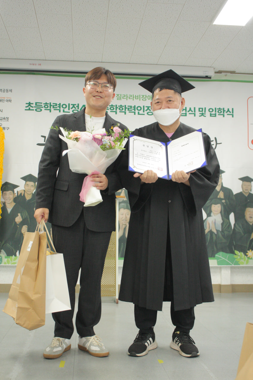 조민제 교장(왼쪽)과 졸업생(오른쪽)이 기념사진을 찍고 있다. 사진 질라라비야학