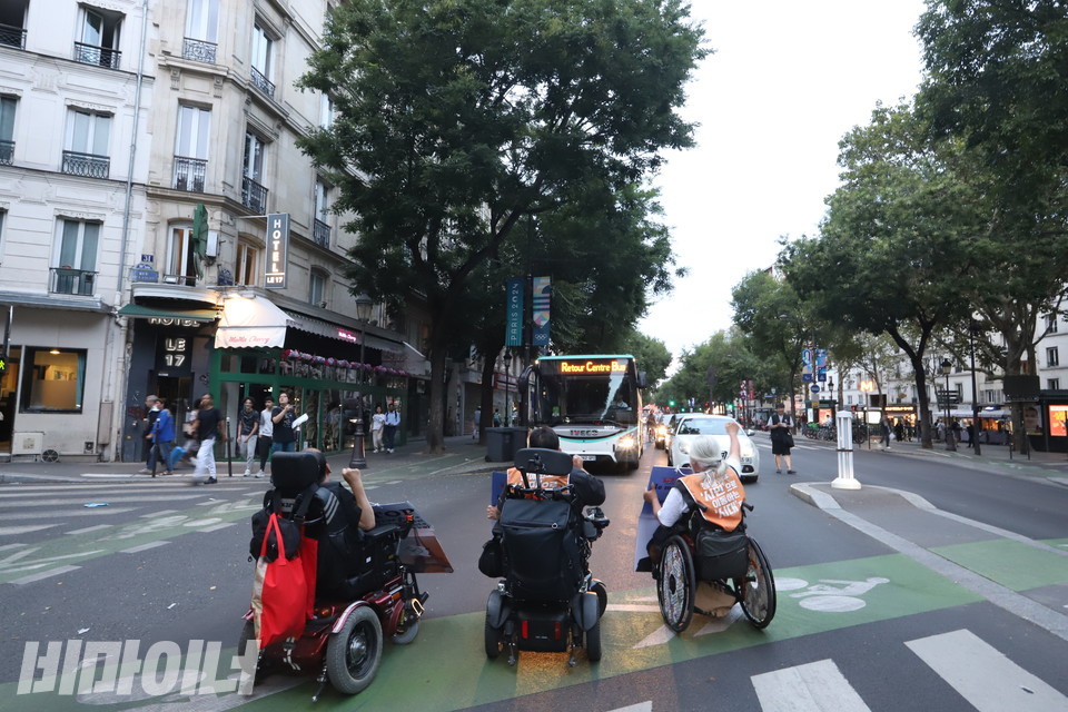 8월 28일, 휠체어를 이용하는 특사단원들이 프랑스 파리 도로를 막는 ‘그린라이트 투쟁’을 벌이며 구호를 외치고 있다. 사진 김소영