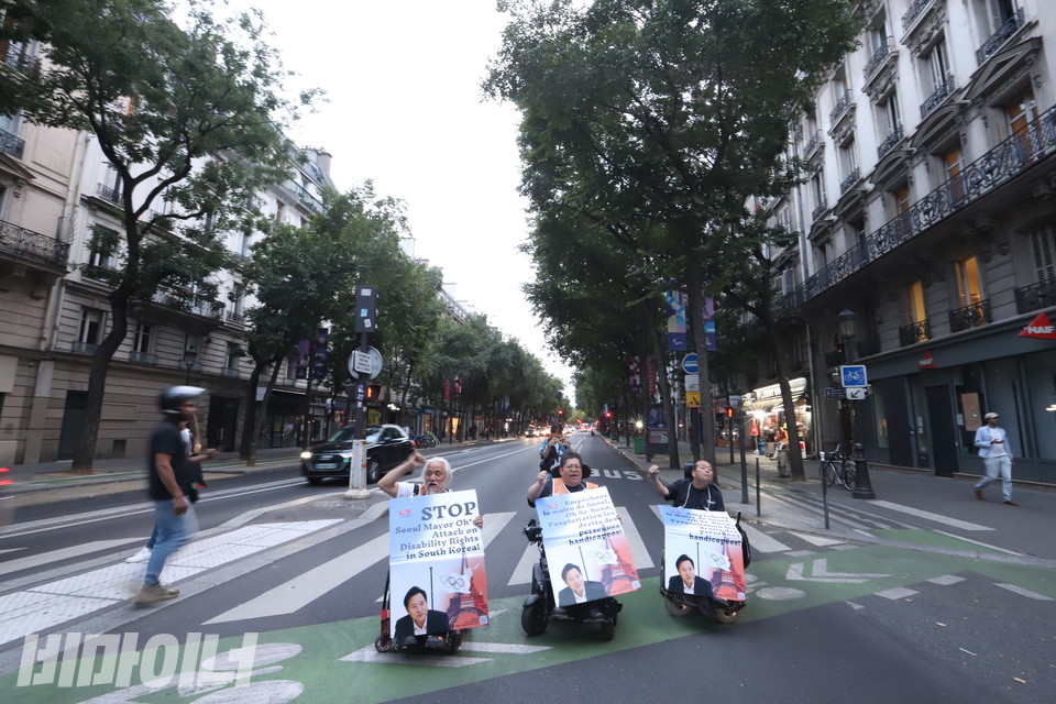 8월 28일, 휠체어를 이용하는 특사단원들이 프랑스 파리 도로를 막는 ‘그린라이트 투쟁’을 벌이며 구호를 외치고 있다. 사진 김소영