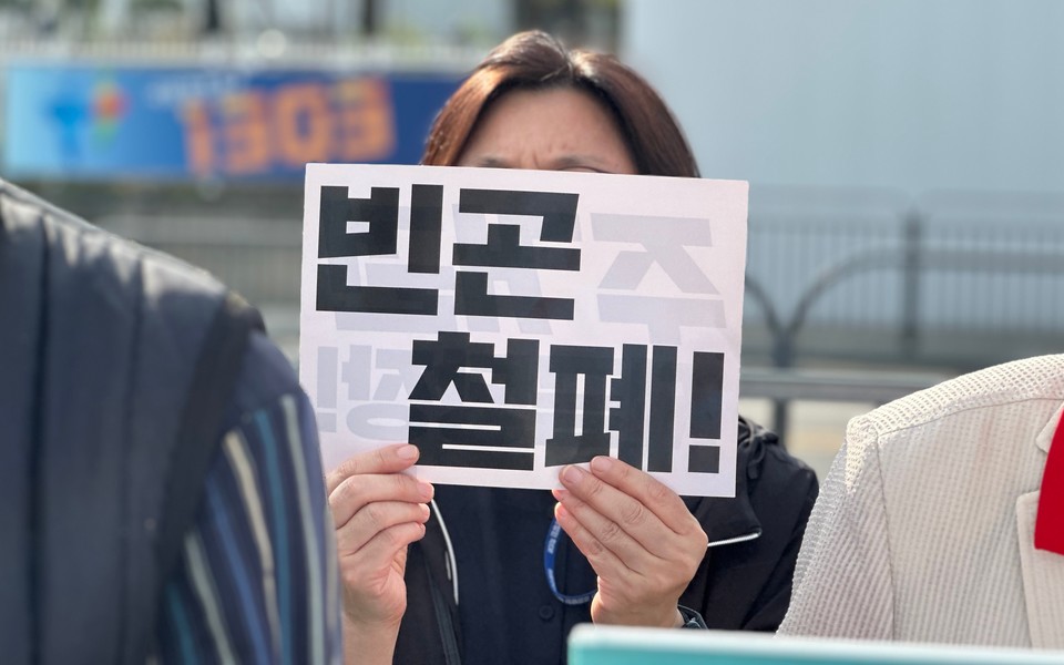 박승민 동자동사랑방 상임활동가가 “빈곤 철폐!”라고 적힌 손팻말을 들고 있다. 사진 1017 빈곤철폐의 날 조직위원회