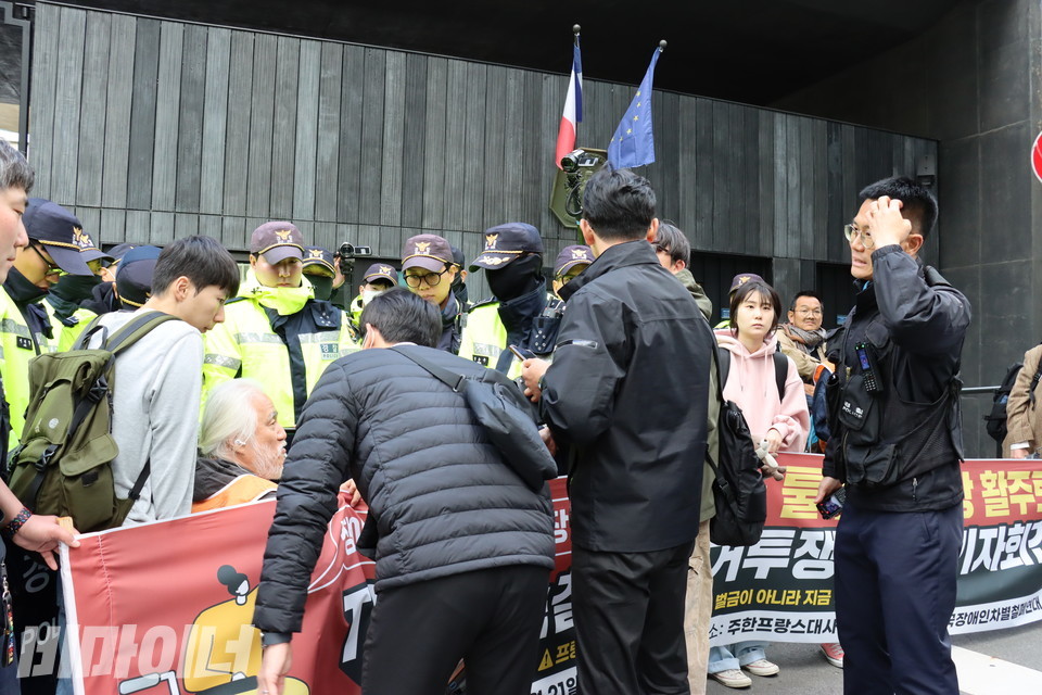 경찰들이 주한프랑스대사관 앞에서 기자회견을 여는 전장연 활동가들을 막고 있다. 사진 김소영