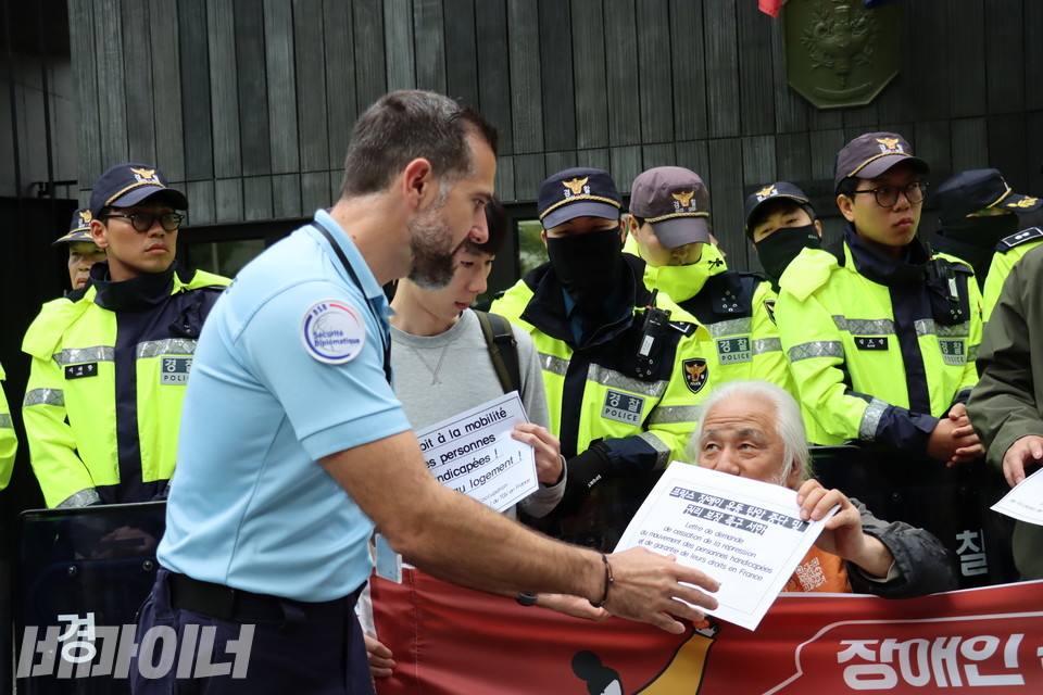 박경석 전장연 상임공동대표가 주한프랑스대사관 직원에게 ‘프랑스 장애인 운동 탄압 중단 및 권리 보장 촉구 서한’을 전달하고 있다. 사진 김소영