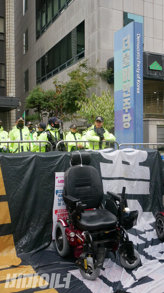 더불어민주당 당사 앞, 텅 빈 휠체어. 해당 휠체어 이용자는 다이인 행동을 하기 위해 휠체어에서 내려와 바닥에 누워 있다. 사진 하민지