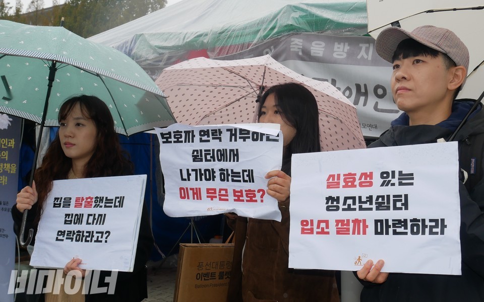 활동가들이 손팻말을 들고 있다. “집을 탈출했는데 집에 다시 연락하라고?”, “실효성 있는 청소년 쉼터 입소 절차 마련하라”라고 적혀 있다. 사진 하민지