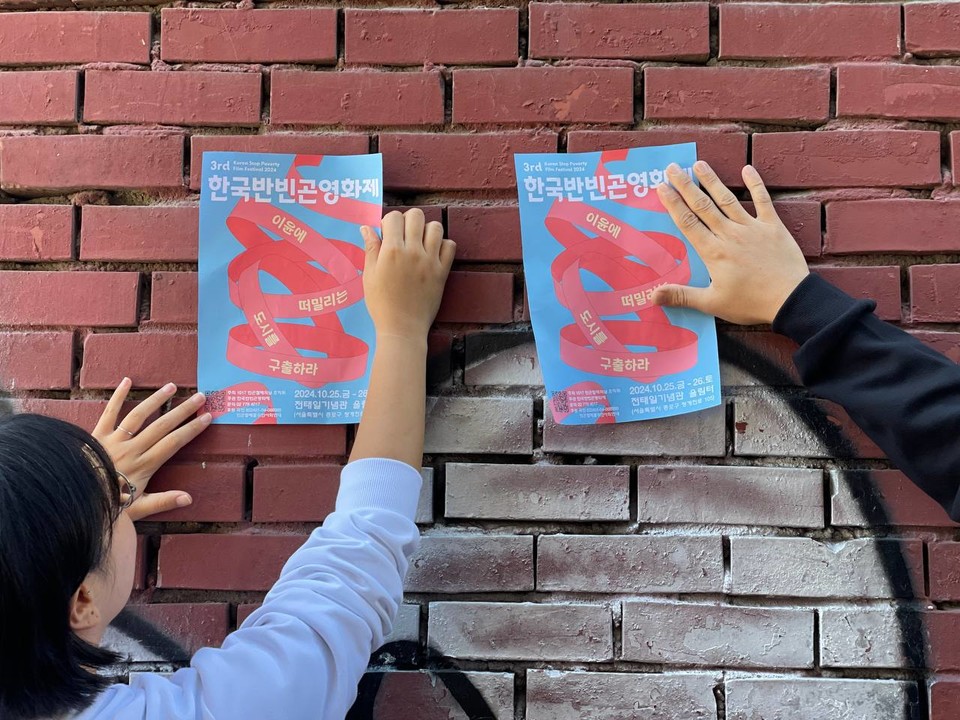 제3회 한국반빈곤영화제 포스터를 붙이는 활동가들. 사진 한국반빈곤영화제