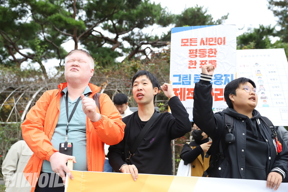 기자회견 참가자들이 주먹을 높이 들며 구호를 외치고 있다. 사진 김소영