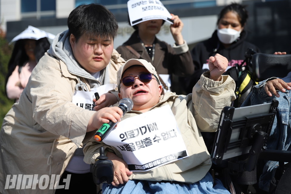 조미경 장애여성공감 공동대표가 투쟁을 외치고 있다. 조 대표가 입은 옷에  “의료기기에 내 몸을 맞출 수 없다”고 적힌 종이 스티커가 붙어 있다. 사진 김소영