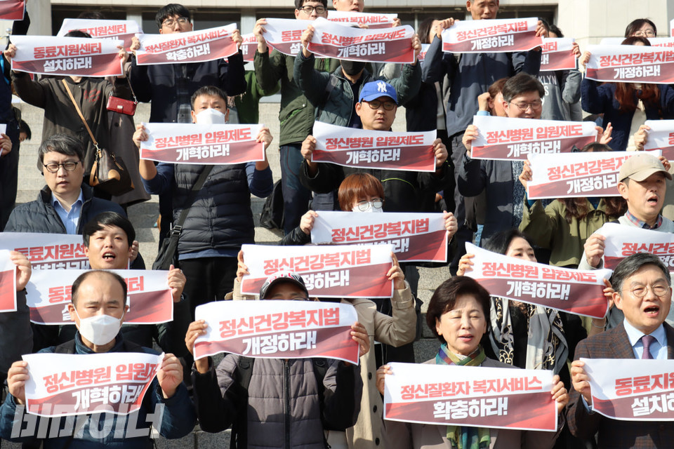 기자회견 참가자들이 작은 현수막을 들고 있다. 현수막에는 “정신건강복지법 개정하라!”, “동료지원센터 설치하라!”, “정신병원 입원제도 개혁하라!”, “정신질환자 복지서비스 확충하라!” 등이 적혀있다. 사진 김소영