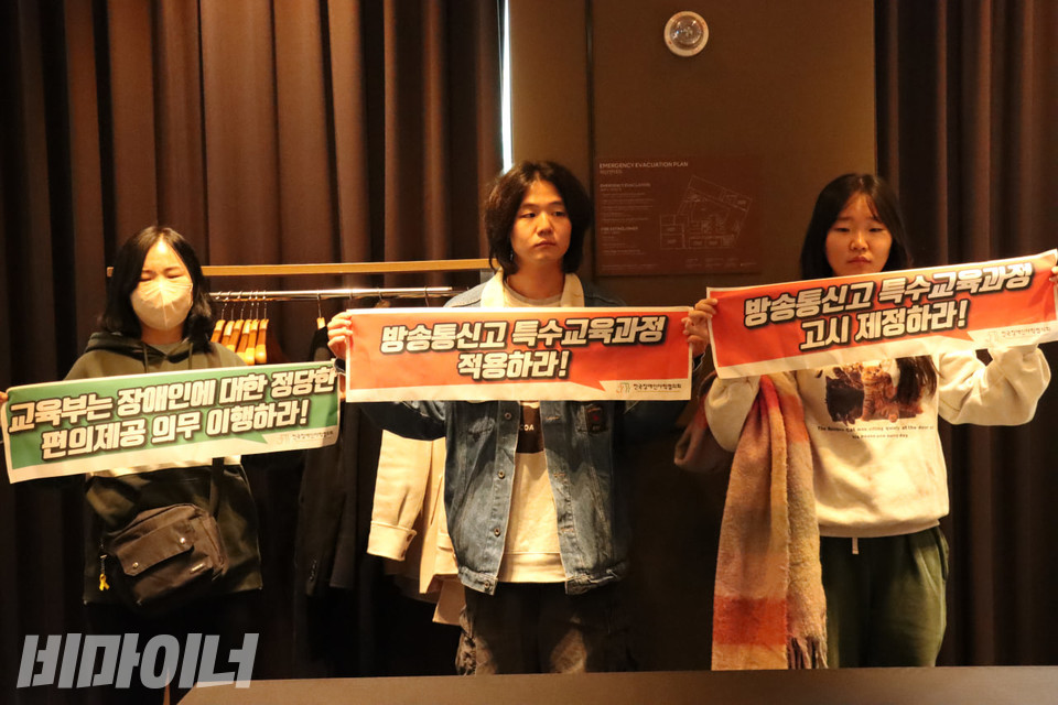 전장야협 활동가들이 방송통신고등학교 시도교육청 협의체 회의장에서 피케팅을 하고 있다. 작은 현수막에는 각각 “교육부는 장애인에 대한 정당한 편의제공 의무 이행하라!”(왼쪽), “방송통신고 특수교육과정 적용하라!”(가운데), “방송통신고 특수교육과정 고시 제정하라!”(오른쪽)라고 적혀있다. 사진 김소영