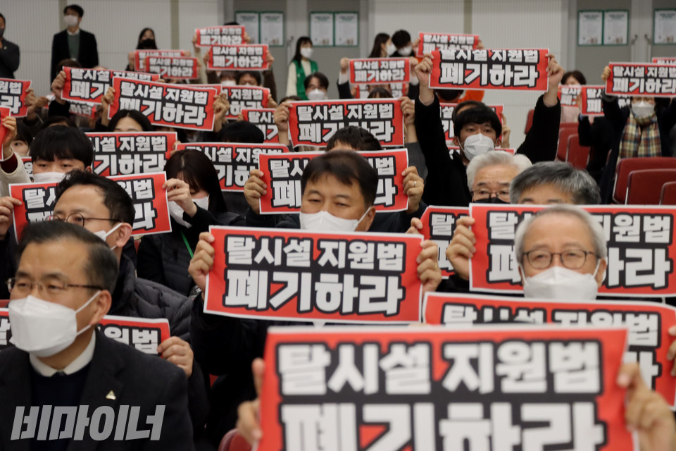 2022년 12월 9일, 서울사회복지법인협회가 서울 강남구 밀알미술관 도산홀에서 ‘장애인 거주시설 정책토론회’를 열었다. 토론회에 참석한 사람들이 ‘탈시설 지원법 폐기하라’는 붉은 손피켓을 들어 보이고 있다. 사진 복건우