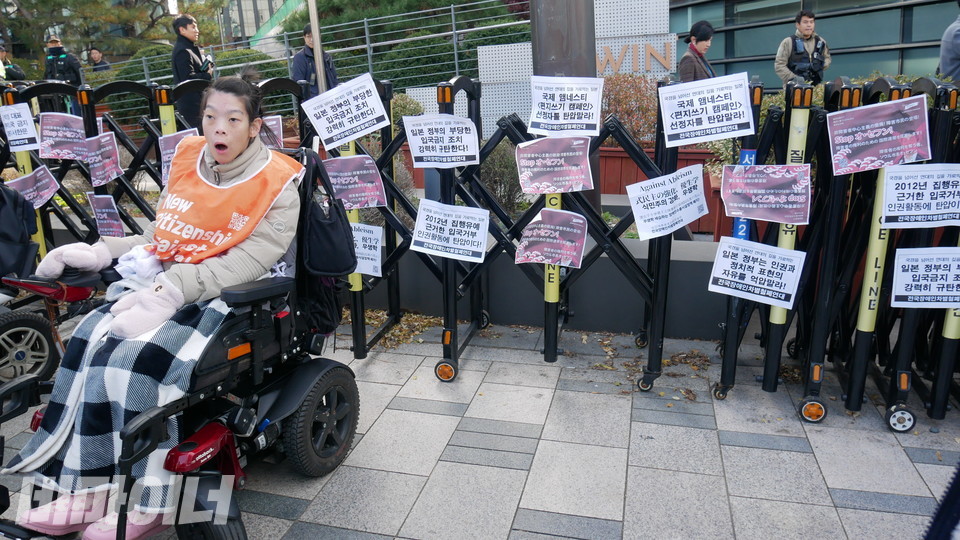 최영은 활동가가 경찰이 친 울타리에 권리스티커를 붙이고 있다. 사진 하민지