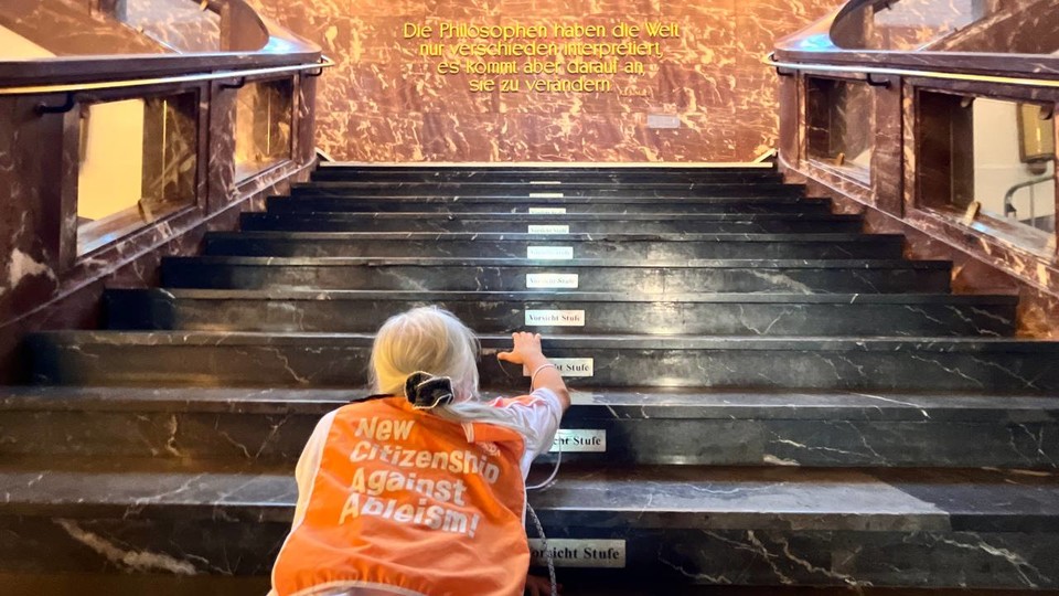 박경석 전국장애인차별철폐연대 상임공동대표가 마르크스의 글귀가 적혀있는 벽 앞 계단을 기고 있다. 계단 칸마다 ‘계단 주의’라는 문구가 붙어있다. 사진 이정한 활동가 제공