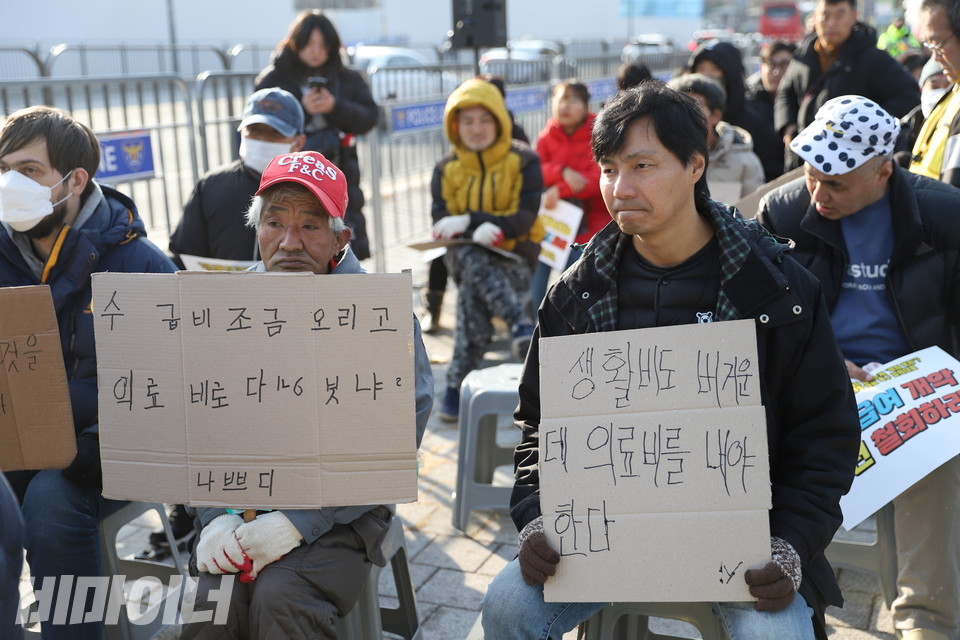 결의대회 참가자들이 직접 글씨를 쓴 피켓을 들고 있다. 각각 “수급비 조금 올리고 의료비로 다 빼앗아 가냐. 나쁘다”(왼쪽), “생활비도 버거운데 의료비를 내야 한다”(오른쪽)라고 적혀있다. 사진 김소영