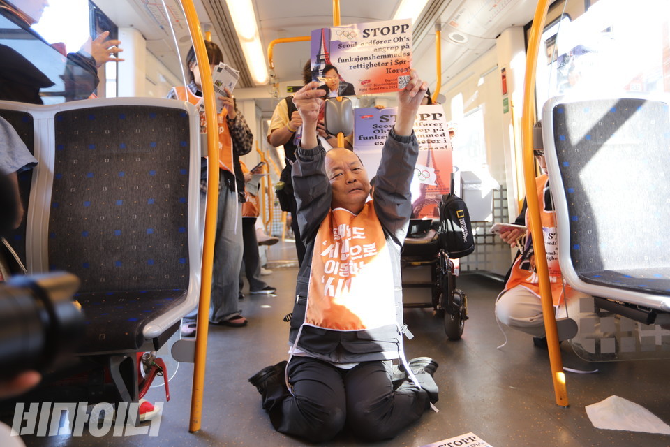 박상호 밀양장애인자립생활센터 소장이 휠체어에서 내려와 오슬로 지하철에서 포체투지를 하고 있다. 사진 김소영