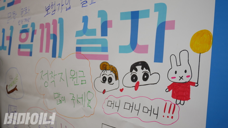 현수막에 다양한 캐릭터와 함께 탈시설지원을 요청하는 문구가 적혀 있다. 사진 하민지
