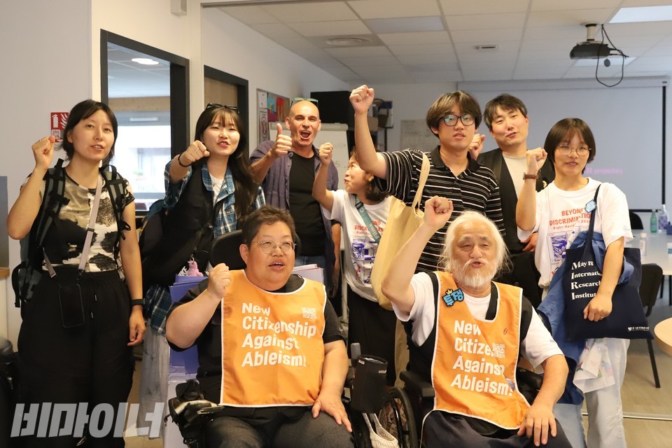 함께 주먹을 쥐고 “투쟁!”을 외치며 사진을 찍는 파스칼 오베르트 이사와 파리 패럴림픽 특사단. 사진 김소영