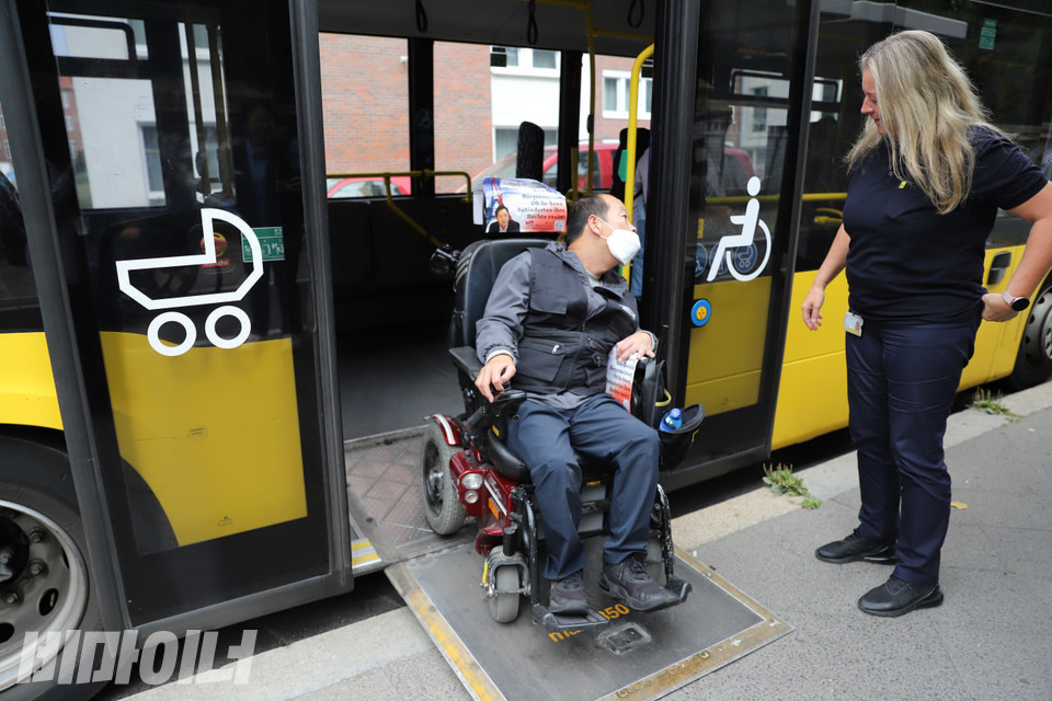휠체어를 타고 있는 박상호 밀양장애인자립생활센터 소장이 경사로를 통해 독일 베를린의 버스에서 하차하고 있다. 버스 문에는 크게 유아차와 장애인 표식이 그려져 있다. 사진 김소영