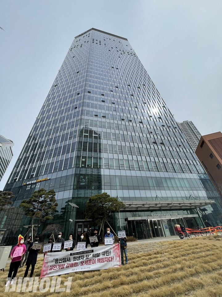 2021년 4월 1일, 용산참사가 일어났던 용산4구역 자리에서 오세훈 서울시장 후보 규탄 용산참사 유가족 긴급기자회견이 열렸다. 참가자들 뒤로 용산 센트럴파크 건물이 높게 서 있다. 사진 하민지