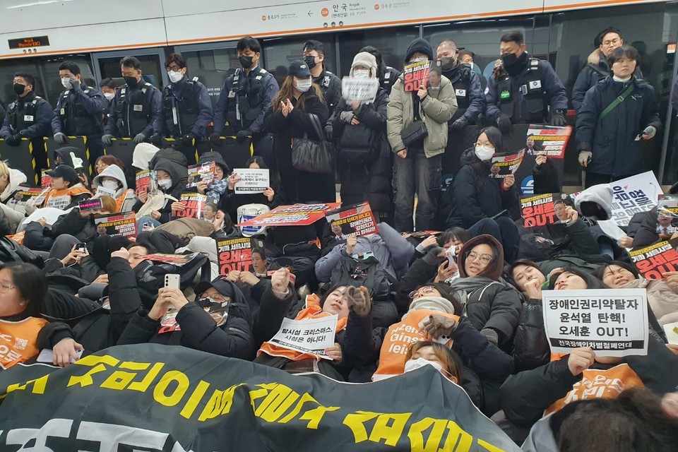 지난 24일, 안국역에서 진행된 ‘10차 출근길 지하철 승강장 다이인 행동’ 현장. 300여 명의 시민이 함께하고 있다. 시민들은 “장애인권리약탈자 윤석열 탄핵! 오세훈 OUT”, “탈시설 크리스마스, 시설은 아니다!”등의 문구가 쓰여있는 종이 피켓을 들고 승강장에 누워있다. 사진 전장연 제공