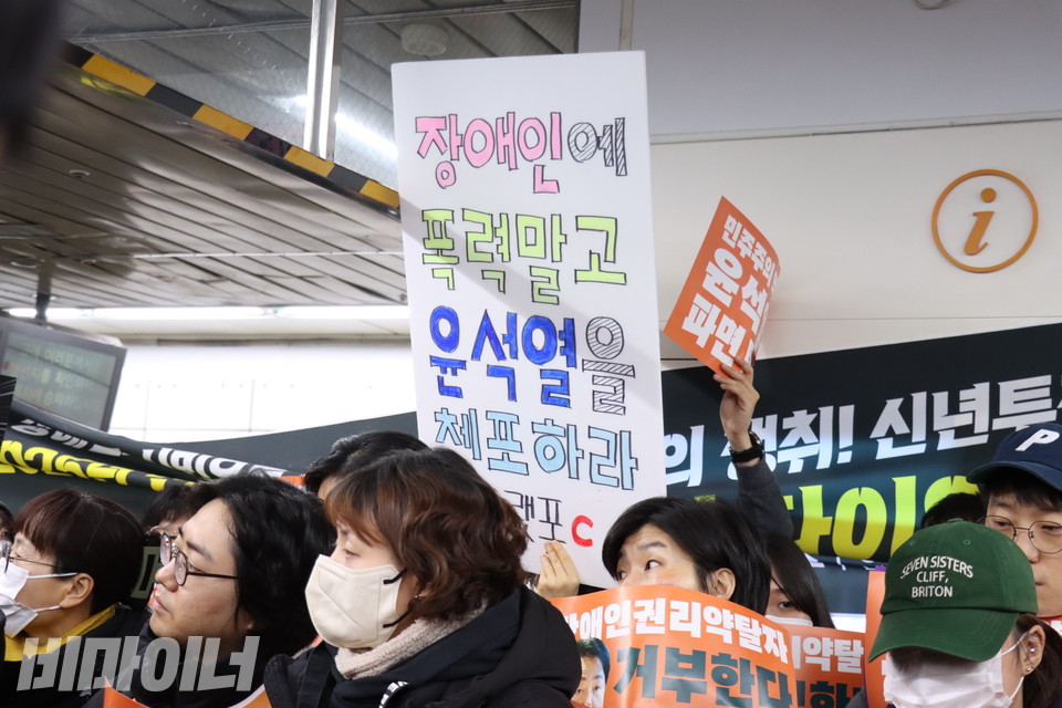 한 시민이 “장애인에 폭력 말고 윤석열을 체포하라”고 적은 피켓을 들고 있다. 사진 김소영