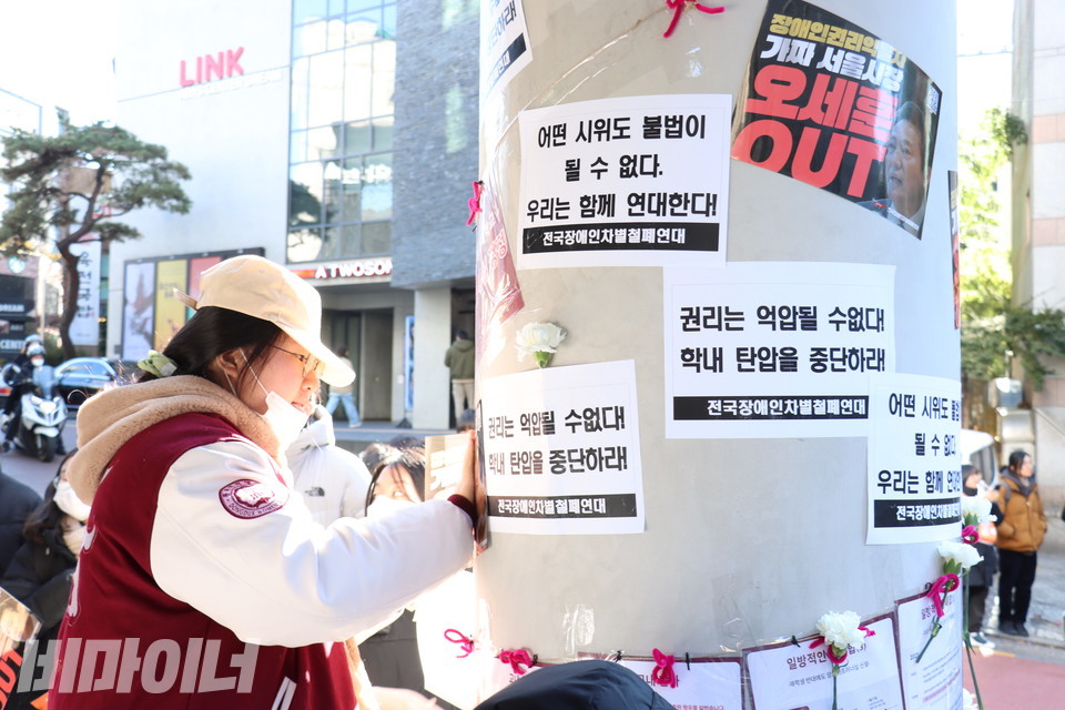 한 시민이 동덕여대 공연예술센터 건물에 ‘권리 스티커’를 부착하고 있다. 사진 김소영
