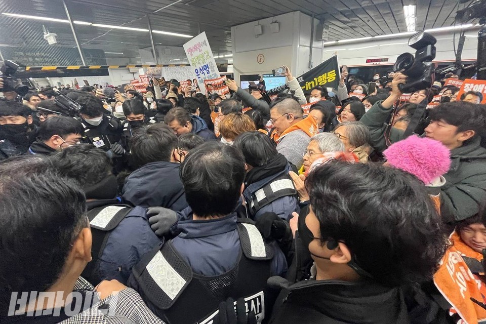 승강장을 가득 메운 시민들과 서울교통공사 보안관들이 대치하고 있다. 사진 김소영