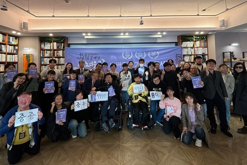 북콘서트에 참여한 발달장애인 당사자, 부모, 활동가들이 기념사진을 찍고 있다. ‘중증 중복 발달장애인 시설수용 종식’ 종이 팻말을 들고 있다. 사진 장애와인권발바닥행동