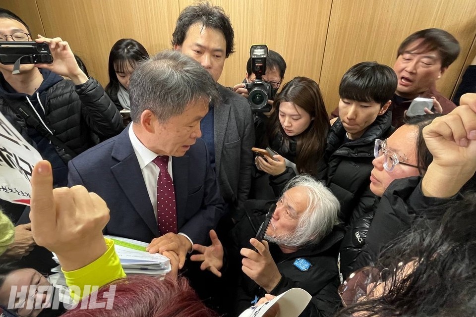 인권위 전원위원회 회의실을 막고 있는 활동가들. 박경석 전국장애인차별철폐연대 상임공동대표가 김용원 인권위원에게 항의 행동에 대한 이유를 설명하고 있다. 사진 김소영