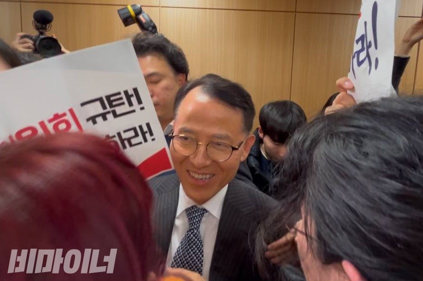 활동가들에게 회의실 입장이 가로막힌 이충상 인권위원이 웃고 있다. 사진 김소영