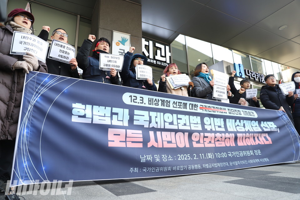 11일, 인권위 바로잡기 공동행동, 차별금지법제정연대, 윤석열즉각퇴진·사회대개혁 비상행동이 인권위 앞에서 기자회견을 열고 ‘내란동조 안건’을 의결한 인권위를 강하게 규탄했다. 기자회견 참가자들이 주먹을 쥐고 구호를 외치고 있다. 현수막에 적힌 ‘국가인권위원회’ 글자가 빨간색 테이프로 가려져 있다. 사진 김소영