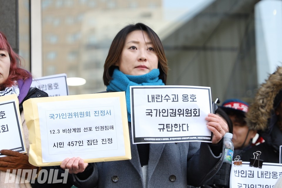 집단 진정에 참여한 국회 인근 주민인 한승주 씨가 인권위 집단 진정서와 “내란수괴 옹호 국가인권위원회 규탄한다”고 적힌 종이 피켓을 들고 있다. 사진 김소영