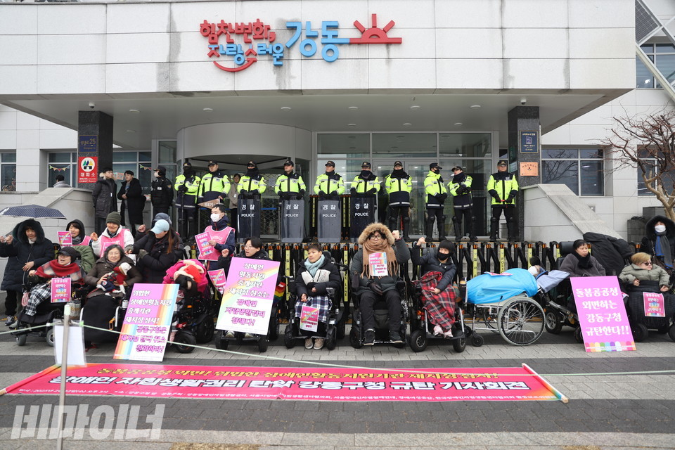 장애여성공감, 서울장애인차별철폐연대 등이 12일 강동구청 앞에서 규탄 기자회견을 열고 있다. 방패를 든 경찰들이 일렬로 서 강동구청 입구를 막고 있다. 사진 김소영