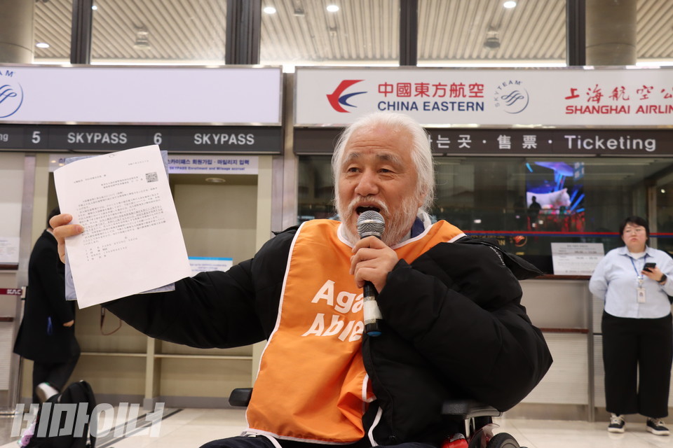 박경석 전장연 대표가 대한항공으로부터 전해 받은 출입국재류관리청의 공문을 들어보이며 발언하고 있다. 사진 김소영