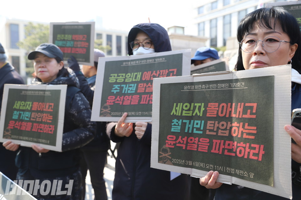 김소연 전국철거민연합 조직국장을 비롯한 기자회견 참가자들이 “세입자 몰아내고 철거민 탄압하는 윤석열을 파면하라”, “공공임대 예산 깎고 주거권 말살하는 윤석열을 파면하라”라고 적힌 피켓을 들고 있다. 사진 김소영