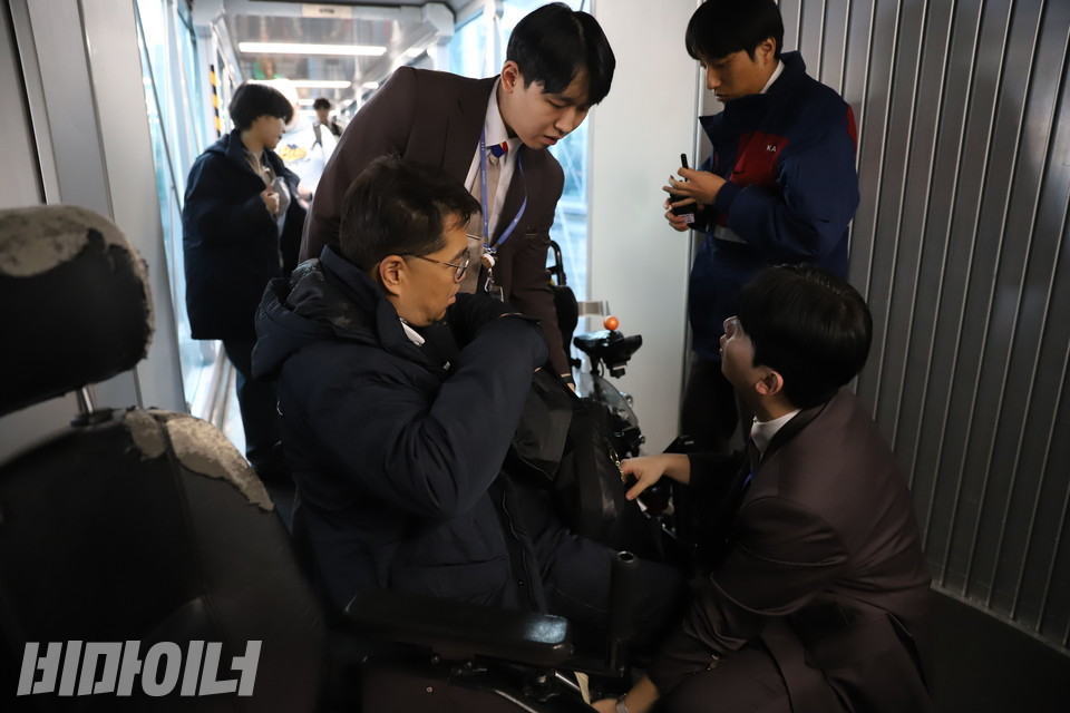 비행기 탑승 직전, 전동휠체어를 탄 조재범 특사단원이 항공사 직원들과 소통하고 있다. 사진 김소영