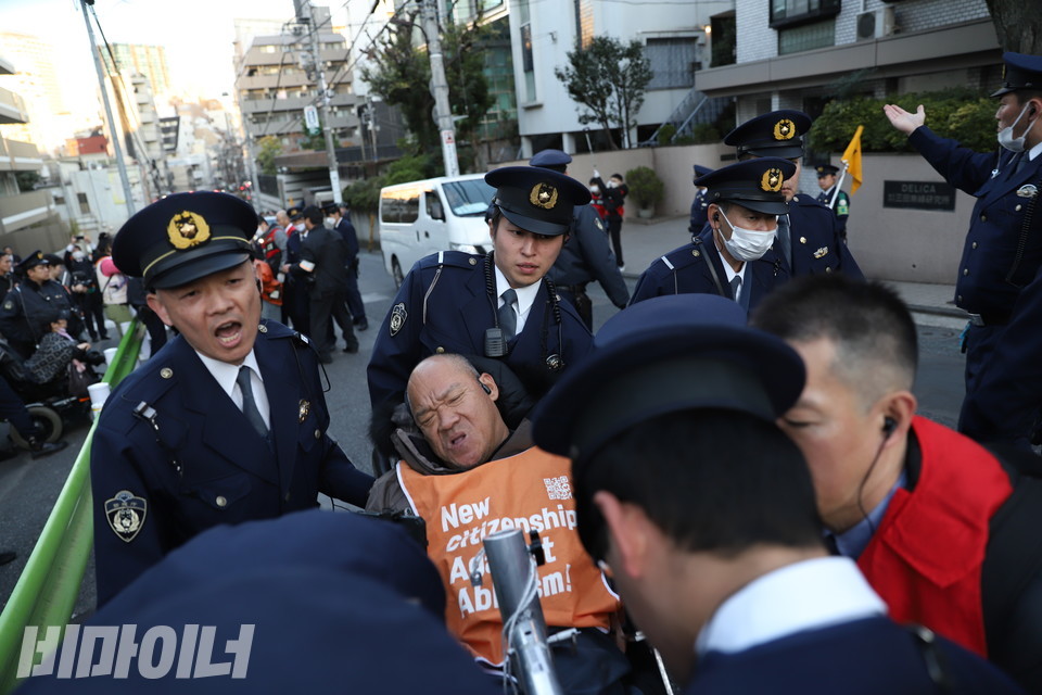 주일본 대한민국 대사관 앞에서 일본 경찰들이 이규식 서울장애인차별철폐연대 대표의 휠체어를 이규식 대표의 동의 없이 들어 올리고 있다. 사진 김소영