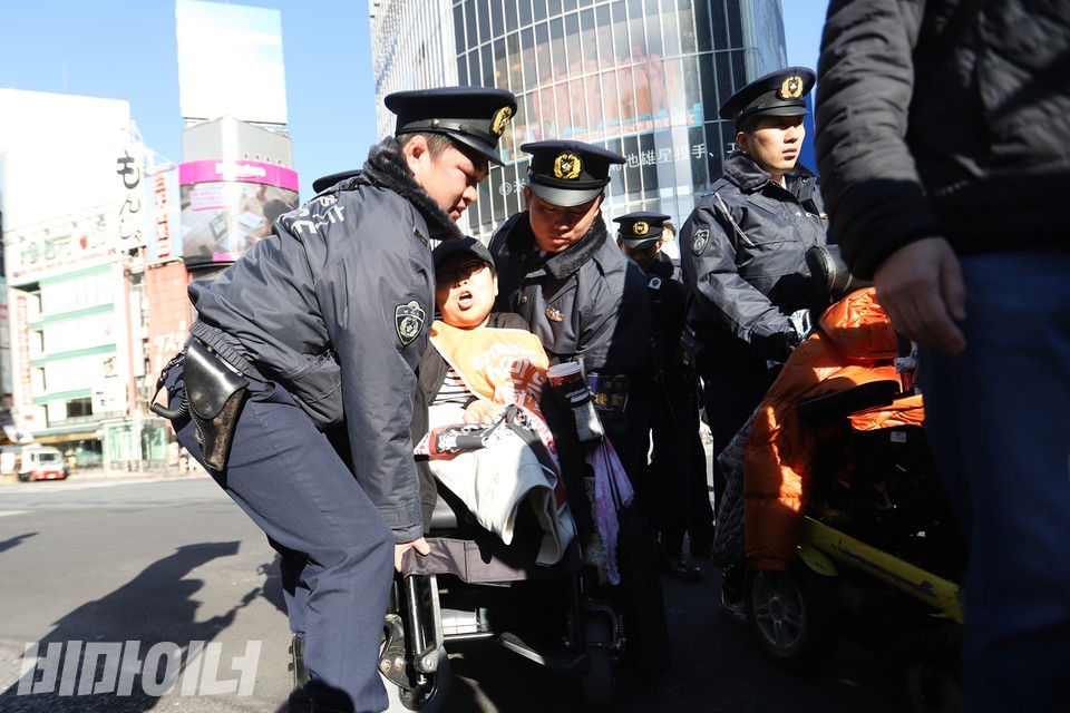 시부야 스크램블 교차로에서 일본 경찰들이 이수미 전국탈시설장애인연대 서울지부 대표의 휠체어를 거침없이 들어올리고 있다. 사진 김소영