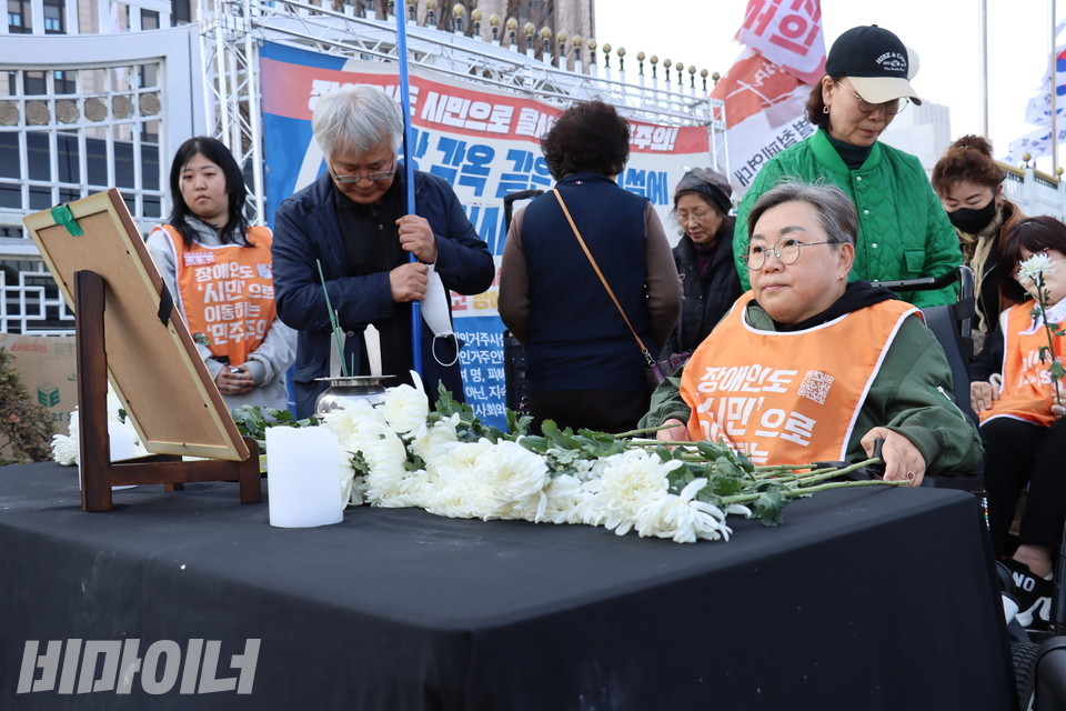 헌화하는 박김영희 장애해방열사_단 대표가 최정환 열사의 영정사진을 바라보고 있다. 사진 김소영
