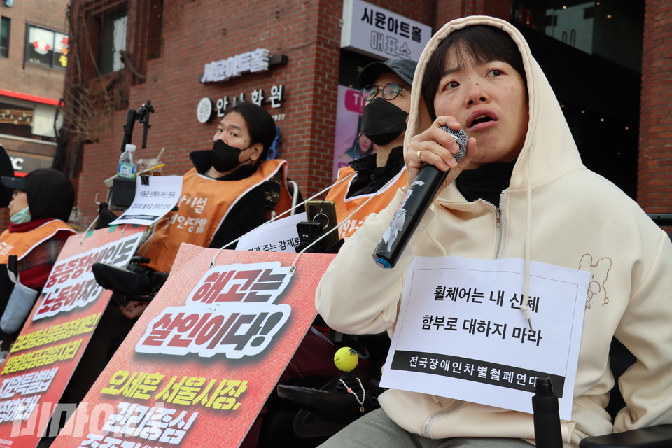 문애린 활동가가 발언하고 있다. 그의 몸에 “휠체어는 내 신체. 함부로 대하지 마라”라고 적힌 스티커가 붙어 있다. 사진 김소영