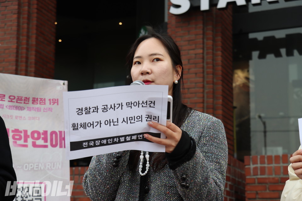 조인영 공익인권법재단 공감 변호사가 발언하고 있다. 그의 손에는 “경찰과 공사가 막아선 건 휠체어가 아닌 시민의 권리”라고 적힌 종이가 들려있다. 사진 김소영