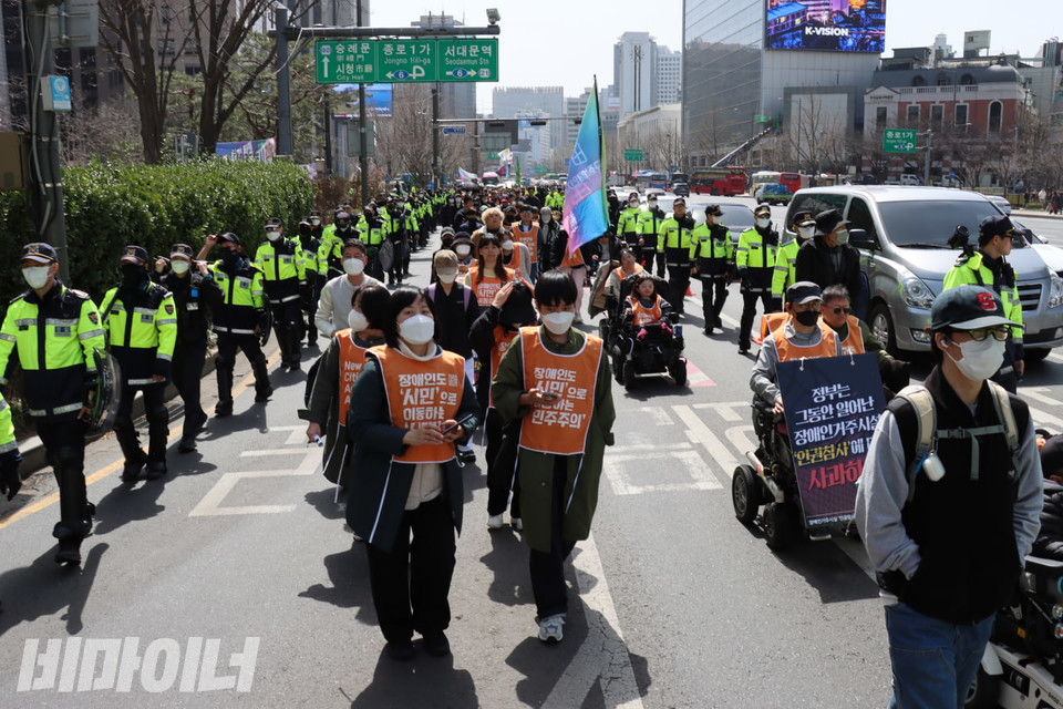장애인들을 비롯한 결의대회 참여자들이 서울 종로구 시내를 행진하고 있다. 사진 김소영