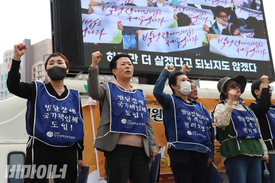 무대에 오른 부모연대 시도지부장들이 주먹 쥔 손을 높이 들며 장애인부모연대가를 부르고 있다. 사진 김소영