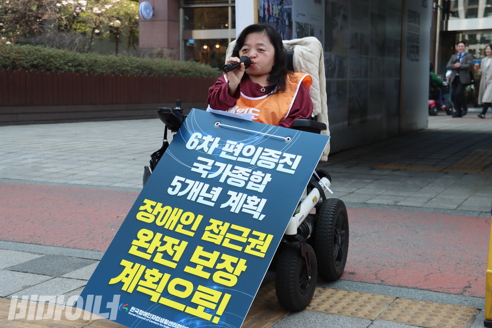 이라나 중구장애인자립생활센터 소장이 발언하고 있다. 그의 앞에는 “6차 편의증진 국가종합 5개년 계획, 장애인 접근권 완전 보장 계획으로!”라고 쓰인 피켓이 놓여있다. 사진 김소영