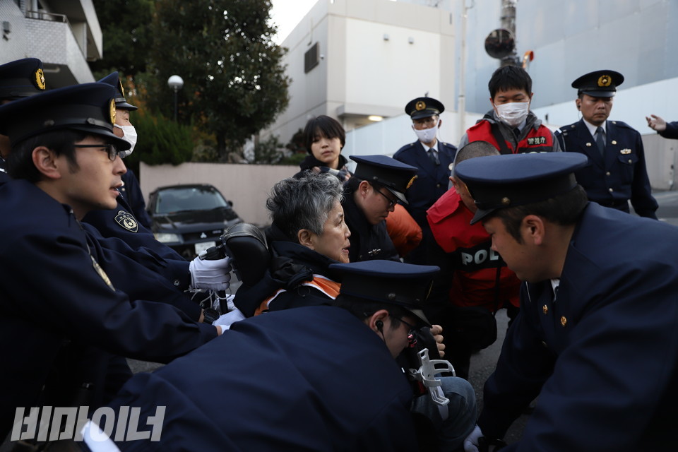 주일본대한민국대사관 앞에서 일본 경찰들이 문경희 대표의 동의 없이 그의 휠체어를 들어 올리고 있다. 사진 김소영