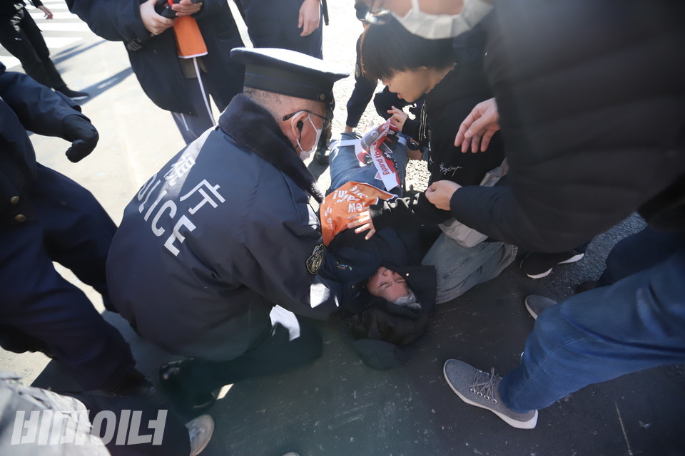 문경희 대표가 시부야 스크램블 사거리에서 다이인 행동을 진행하고 있다. 도로 위에 누워있는 문 대표에게 일본 경찰이 일어나라고 말하고 있다. 사진 김소영