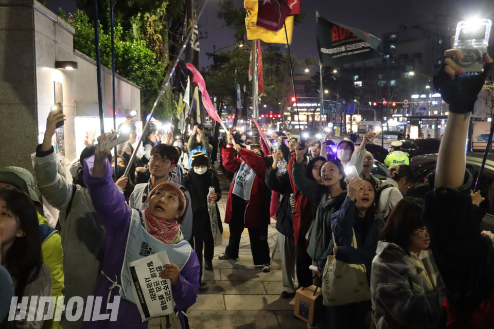 문화제 참여자들이 플래시를 켜고 고공농성자들이 있는 하늘을 비추고 있다. 사진 김소영