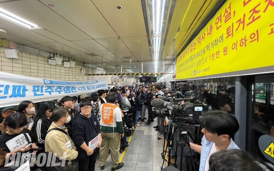 “진짜 민주주의는 62차 출근길 지하철 탑니다”라고 적힌 현수막 건너편에 혜화역장이 붙인 경고 현수막이 있다. 사진 하민지