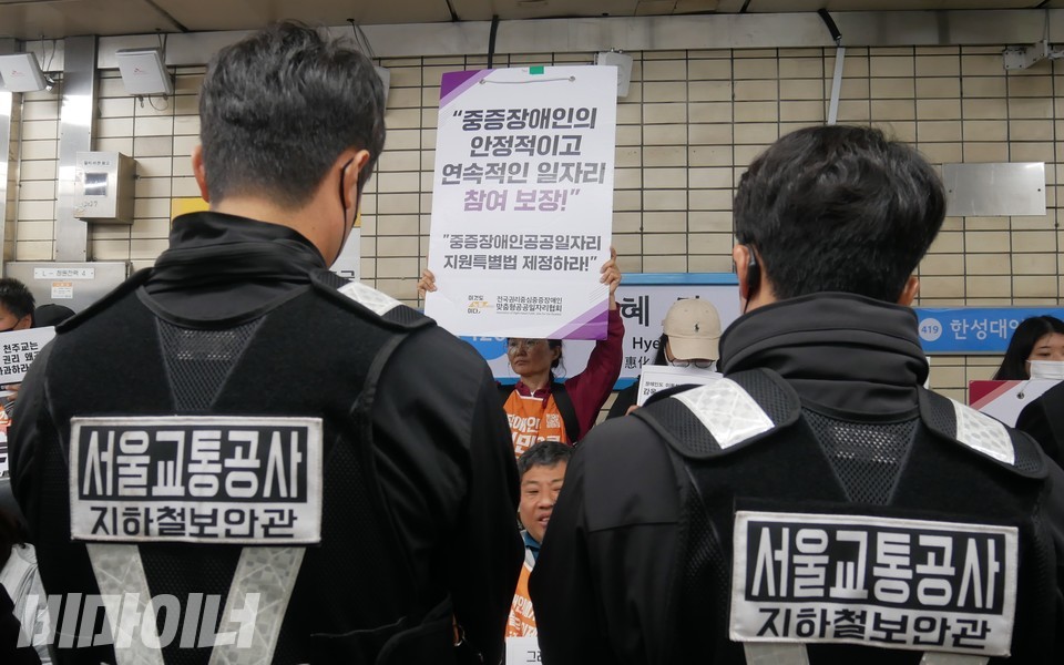 서울교통공사 직원들 사이로 장애인 노동권 보장을 요구하는 피켓이 보인다. 사진 하민지