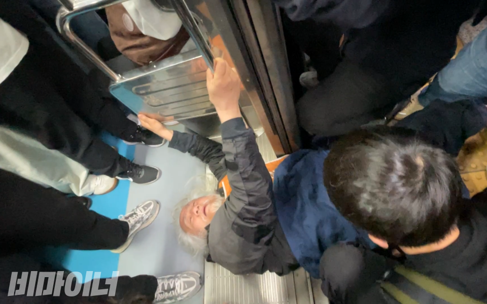 서울교통공사의 폭력을 뚫고 탑승을 시도 중인 박경석 전장연 대표. 사진 하민지
